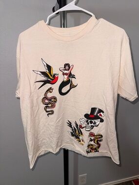 Hot Topic Cream Graphic Tee with Black, Red & Yellow Tattoo Art